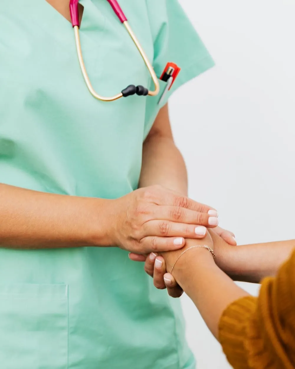 Profesional de la salud sosteniendo la mano de una paciente